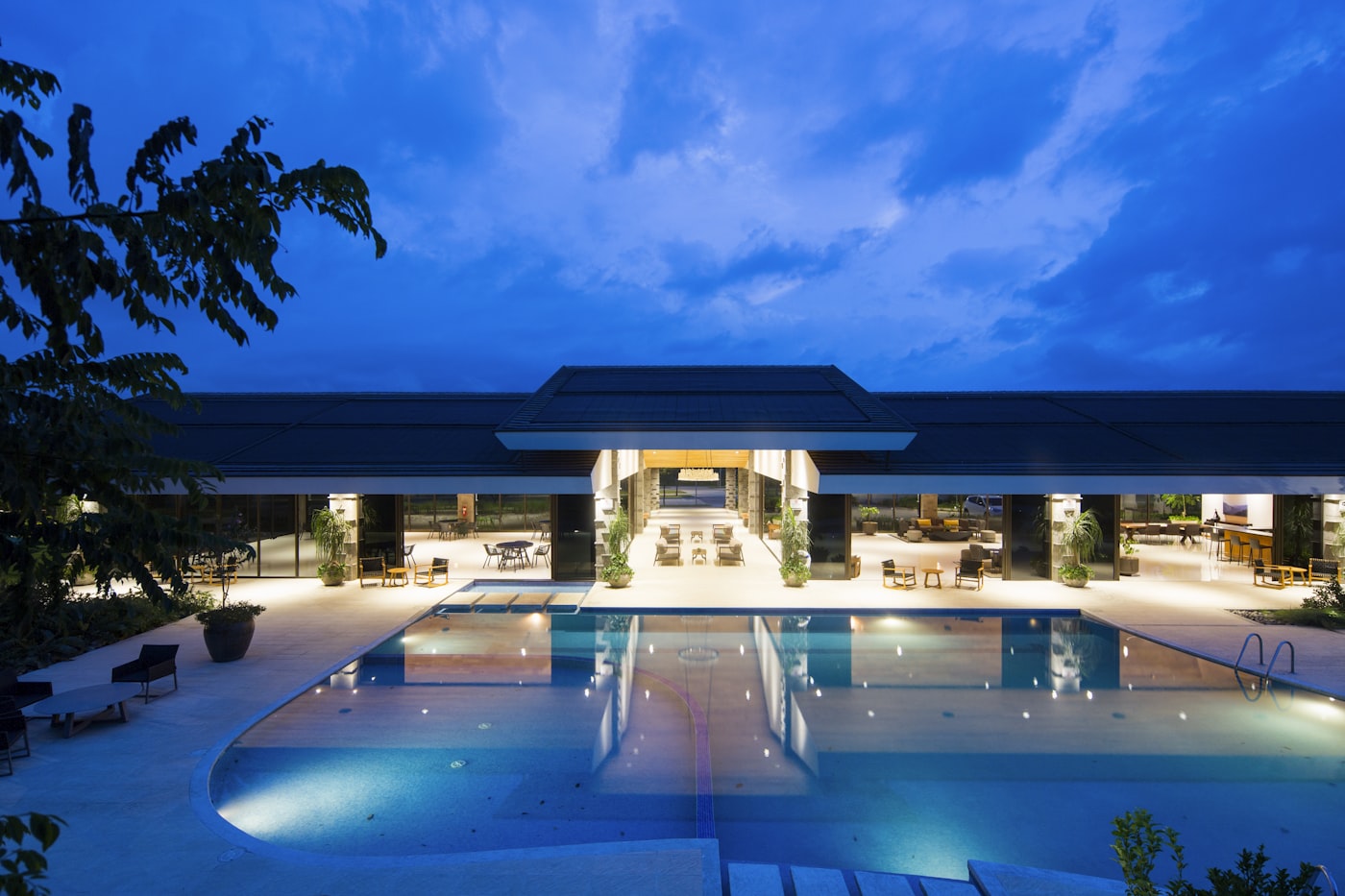 Hotel pool and guest building at dusk