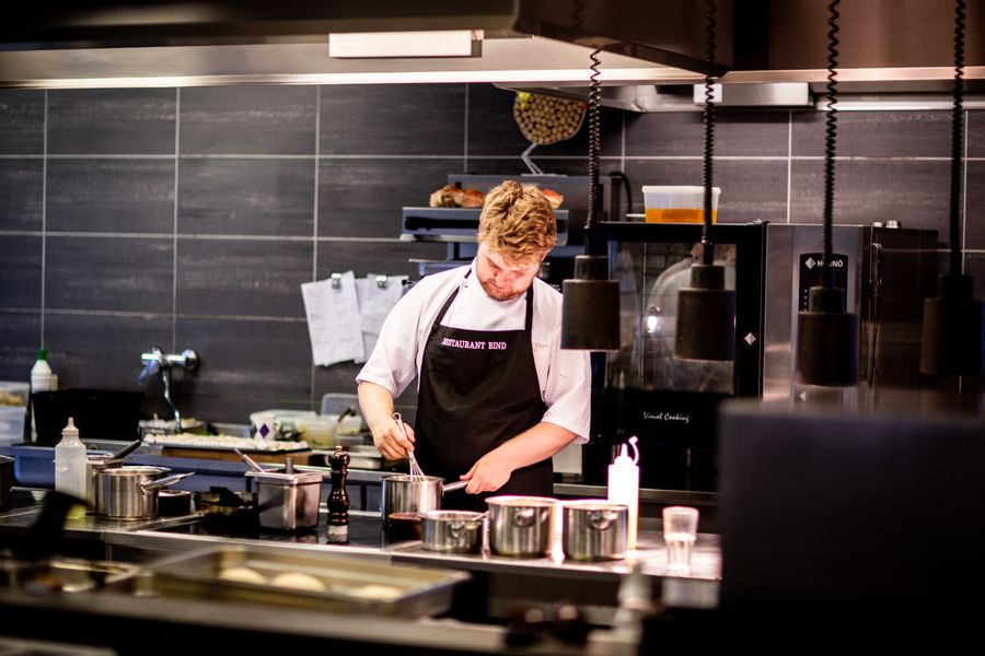 Commercial kitchen with stainless steel ovens, hood, and cooktop